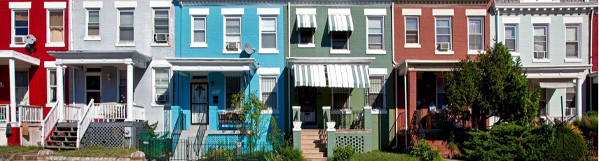 Different collored buildings stacked right nexted to each other no space in between.